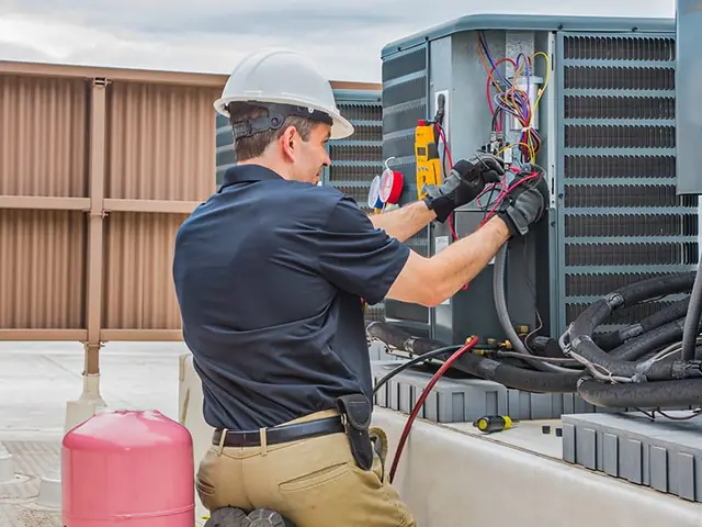 Technician wiring an outdoor condensing unit