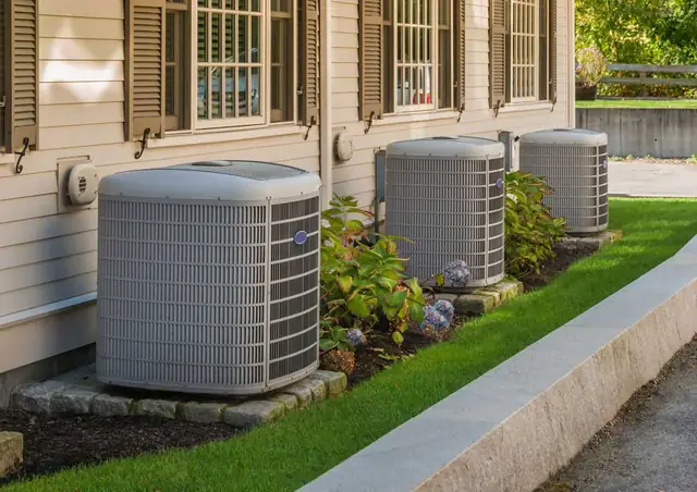 Residential air conditioning condensers beside a Woodlands home