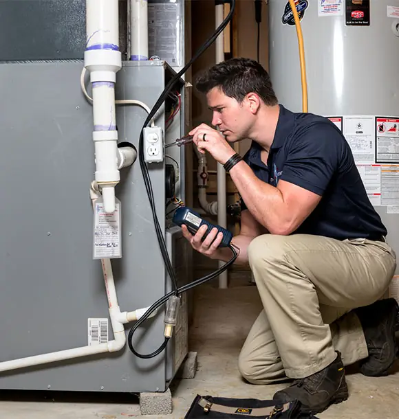Technician testing an indoor furnace with a meter